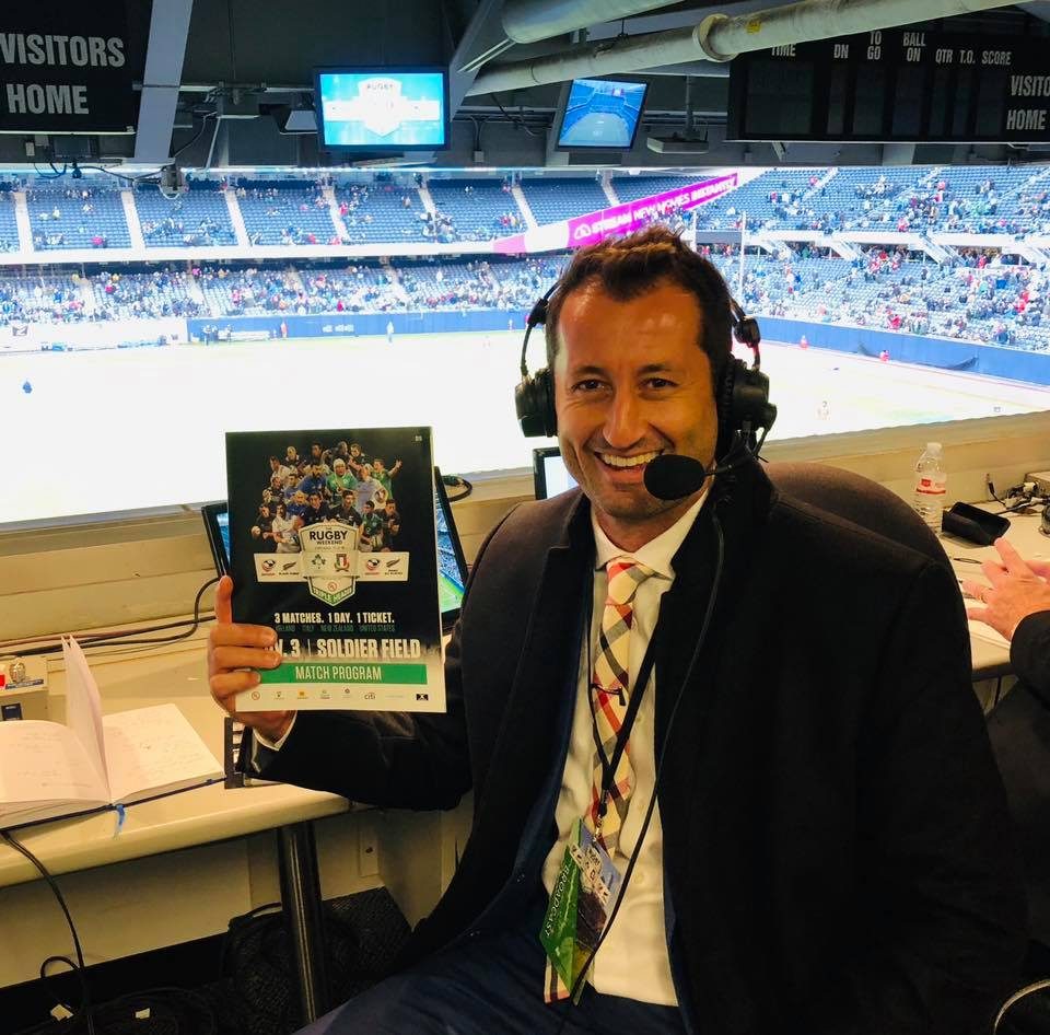 Dallen Stanford in the commentary box with his headset and match program before kickoff